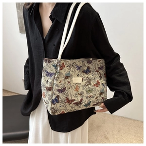 Detail of floral butterfly canvas tote bag featuring jacquard fabric and leather straps