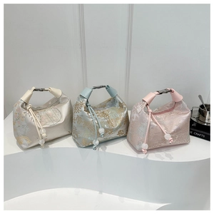 Detail of jacquard fabric handbags featuring traditional Chinese scenery and metal buckles