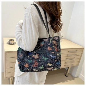 Detail of colorful butterfly jacquard tote bag showing texture and slim shoulder straps