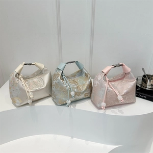 Three Chinese-style jacquard handbags in champagne, light blue, and pink on display