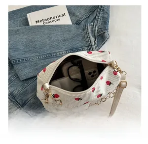 Vue détaillée du sac en velours fraise montrant la capacité pour téléphone et portefeuille