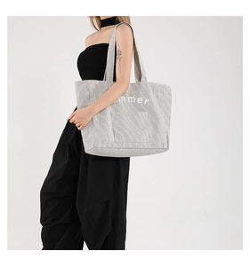 Detailed side view of large canvas tote bag with black and white stripes and summer print