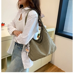 Détail du grand sac cabas en toile vert olive avec poche latérale et pendentif cartoon