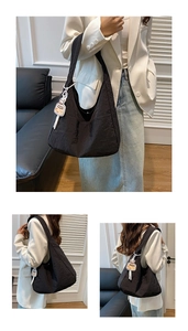 Gros plan détaillé du sac bandoulière noir plissé avec petit pendentif bouteille
