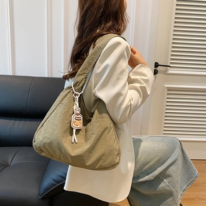 Sac bandoulière en toile vert olive avec texture plissée et breloque bouteille