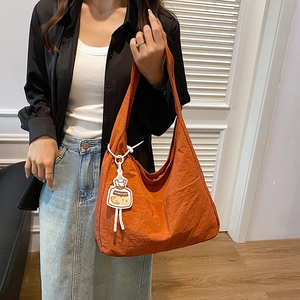 Grand sac cabas en nylon orange vif avec breloque dessin animé en scène de style de vie