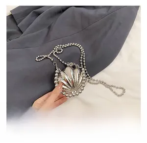 Dettaglio mini borsa a conchiglia argento con finitura specchiata e tracolla a catena chic