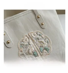 Détail de la broderie florale et de la texture plissée sur ce grand sac cabas