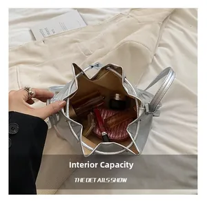 Interior capacity detail of the silver drawstring bucket bag with cosmetics inside