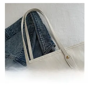 Détail de la bandoulière confortable et broderie dorée sur sac cabas en toile crème