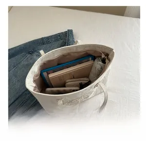 Vue détaillée de l'intérieur d'un grand sac cabas blanc avec broderies de fleurs