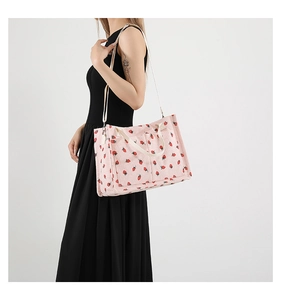 Pink corduroy tote bag with strawberry print shown on model for size and style