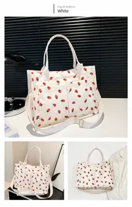 Detailed view of white corduroy tote bag with strawberry print and front utility pockets