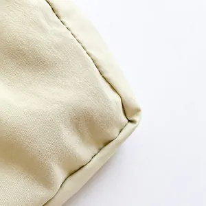 Dettaglio del tessuto in nylon crema con trama fine e cuciture sui bordi precise