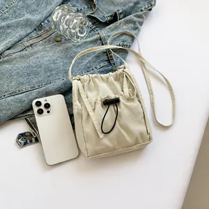 Dettaglio borsa a tracolla in nylon bianco sporco con tessuto a pieghe e coulisse