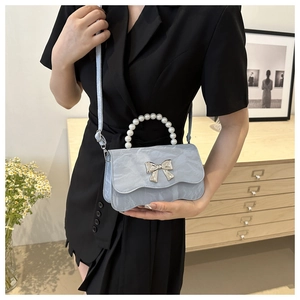 Detail showing marble texture blue purse with pearl handle and silver bow clasp