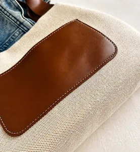 Detail der Canvas-Einkaufstasche mit braunem Lederpatch und weißer Kontrastnaht
