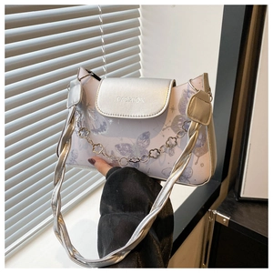 Detailed macro view of the silver butterfly print and metal chain on this lilac underarm bag