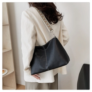 Large black hobo tote with wide geometric strap and white contrast stitching detail