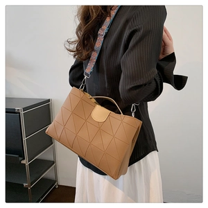 Dettaglio della borsa tote kaki con cuciture geometriche e tracolla colorata