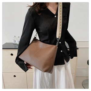 Brown leather tote bag with vertical stitching and geometric pattern wide shoulder strap
