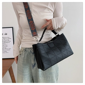 Dettaglio della borsa tote trapuntata geometrica nera con tracolla in tessuto colorato