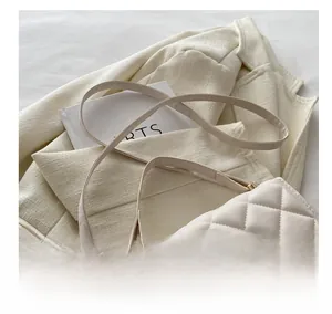 Gros plan sur le sac à bandoulière matelassé crème avec garniture en métal doré chic