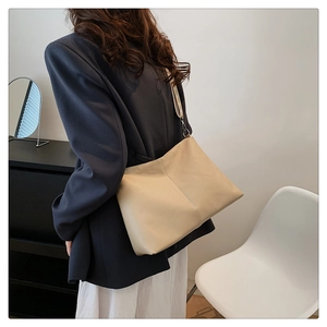 Chic beige underarm bag with lychee texture and stitching detail shown on shoulder