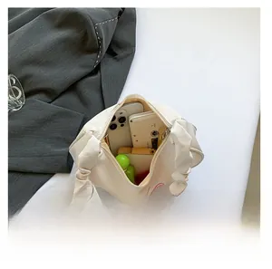 Interior view of the cream pleated shoulder bag showing smartphone and cosmetic storage