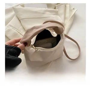 Detail showing the spacious interior and smooth zipper of this beige pleated handbag