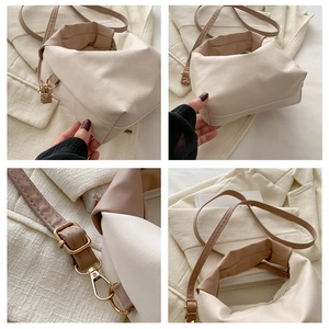 Detail view of two-tone cream and brown crossbody bag with gold hardware and adjustable strap