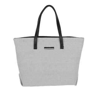 Large off-white woven canvas tote bag with black handles and silver logo plaque