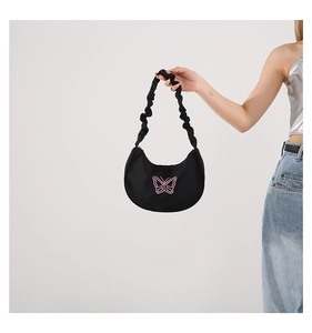 Detail of black crescent hobo bag featuring pink butterfly embroidery and scrunchie strap