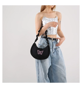 Detail of butterfly embroidery on black ruched shoulder bag with Y2K aesthetic design