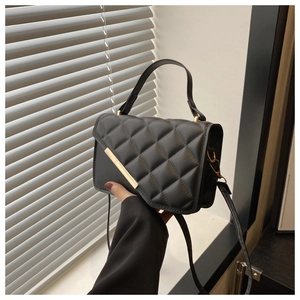 Détail d'un sac bandoulière noir matelassé en similicuir avec boucle en métal doré