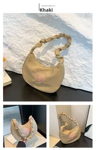 Detail of khaki hobo bag featuring pink butterfly embroidery and scrunchie shoulder strap