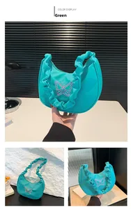Detail of mint green nylon crescent shoulder bag with pink butterfly embroidery