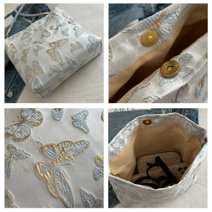 Detailed views of butterfly embroidery, bronze magnetic buckle, and interior bag capacity