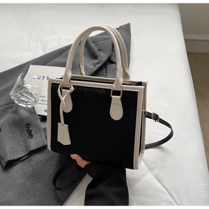 Dettaglio di una borsa tote chic bianca e nera con texture opaca e doppi manici