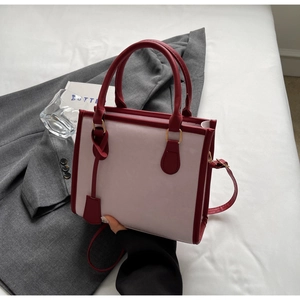Dettaglio della borsa rosa con contrasto rosso vino e tracolla rimovibile in pelle PU