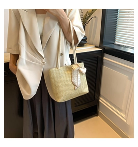 Détail du sac cabas en paille avec foulard en soie à cœurs et bandoulière en corde