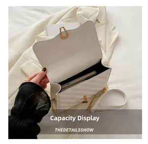 Detail shot showing internal capacity of white quilted crossbody bag fitting a smartphone