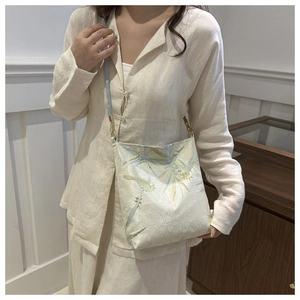 Detail of embroidered brocade bucket bag with bamboo patterns and golden hardware