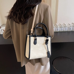 Elegante borsa tote beige e nera con manici superiori e tracolla regolabile rimovibile