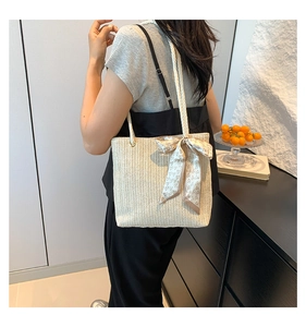 Détail du sac cabas en paille avec texture tissée et foulard décoratif à cœurs