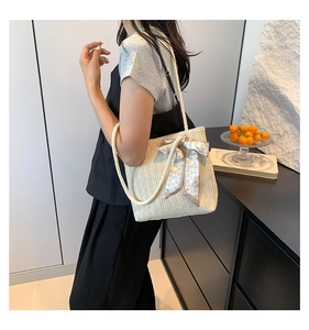 Détail du sac en paille avec anses en corde et foulard décoratif à motif de cœurs