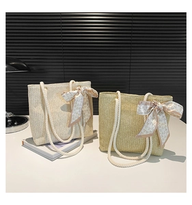 Détail de sacs cabas en paille montrant la texture en V et le foulard décoratif à cœurs