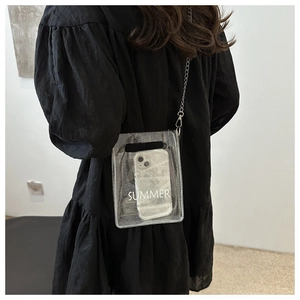 Model draagt een transparante PVC-telefoontas met glitters en een metalen kettingriem