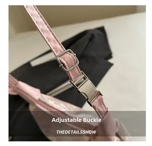 Detail view of the pink shoulder bag featuring a silver adjustable metal buckle and leather strap