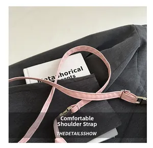 Detail view of pink leather adjustable shoulder strap with silver metal buckle and hooks